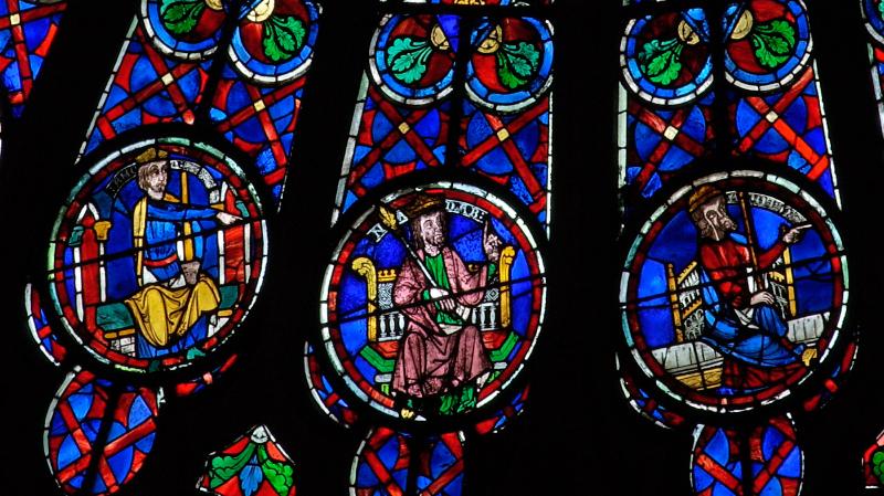 Un maître verrier médiéval au travail, représentant l'art de la construction des vitraux des oculi de Notre-Dame de Paris